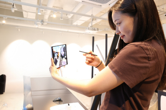 방문객이 LG유플러스 MZ취향 커뮤니티 '일상비일상의틈byU+'에서 갤럭시Z폴드6을 활용해 방탈출 게임을 즐기고 있다. LG유플러스 제공